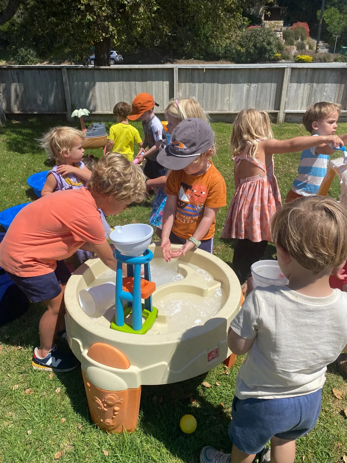 Children learning and playing together at an outdoor water table